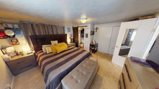 carpeted bedroom with a textured ceiling, a closet, and a barn door