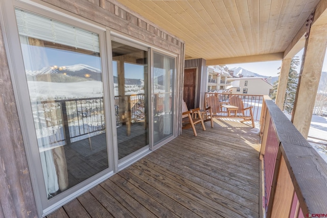 snow covered deck with a mountain view