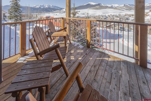 snow covered deck with a mountain view