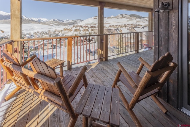 snow covered deck featuring a mountain view