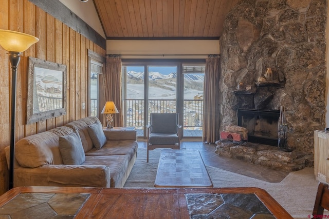 living room featuring lofted ceiling, wood walls, a stone fireplace, and wooden ceiling