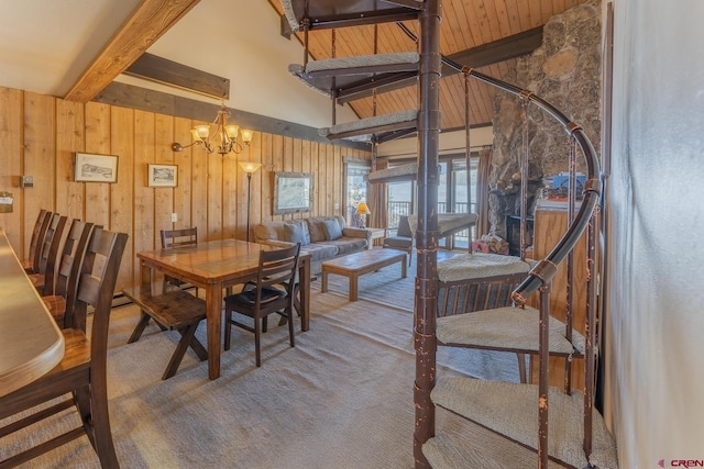 dining room with carpet, wood walls, beamed ceiling, and an inviting chandelier