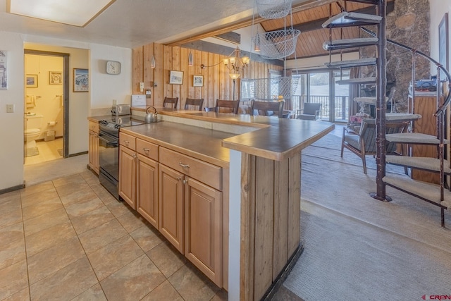 kitchen featuring decorative light fixtures, black range with electric stovetop, a notable chandelier, and light tile patterned flooring