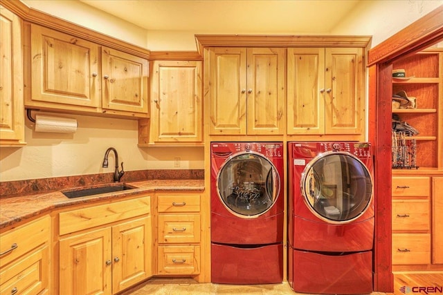 laundry room featuring cabinets, washing machine and clothes dryer, and sink