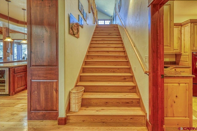 stairway featuring wine cooler, a healthy amount of sunlight, and hardwood / wood-style floors