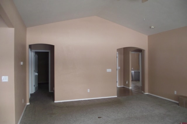 carpeted empty room featuring vaulted ceiling