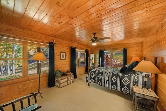 carpeted bedroom with ceiling fan, wood walls, and wooden ceiling