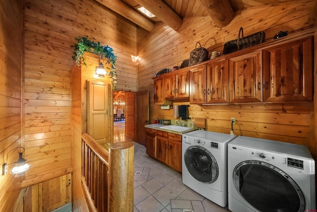 laundry room featuring washer and dryer, sink, light tile patterned floors, and wooden walls