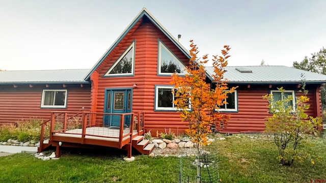 back of house featuring a lawn and a wooden deck