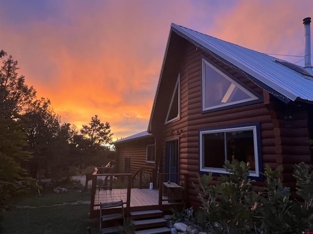 back house at dusk with a wooden deck