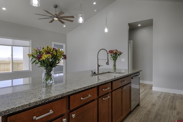 kitchen with light stone counters, a sink, ceiling fan, light wood-type flooring, and dishwasher