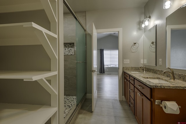 bathroom featuring lofted ceiling, double vanity, tile patterned flooring, and a sink