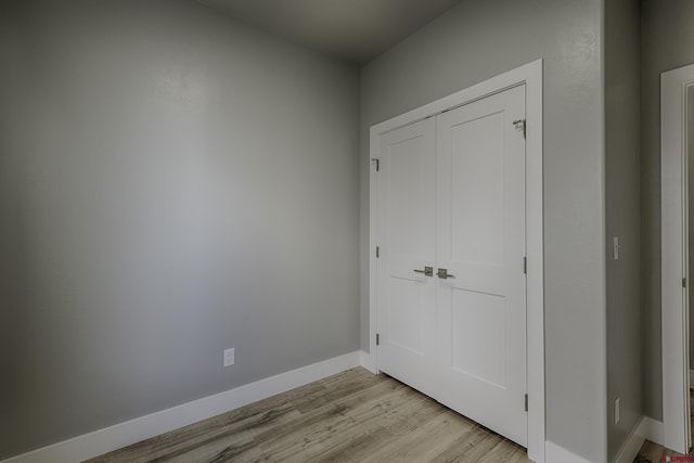 unfurnished bedroom featuring light hardwood / wood-style floors and a closet