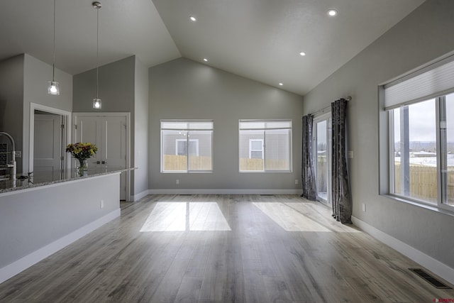 unfurnished living room featuring light wood-type flooring, visible vents, and plenty of natural light