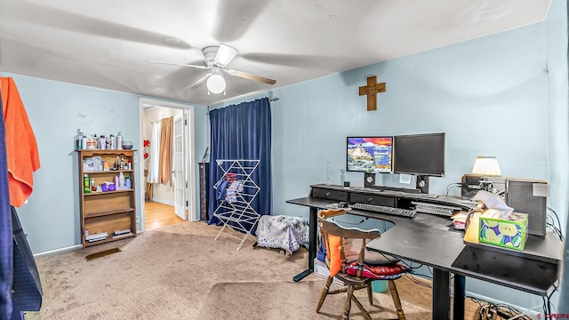 office space featuring light carpet and ceiling fan