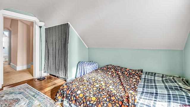 bedroom featuring vaulted ceiling and hardwood / wood-style flooring