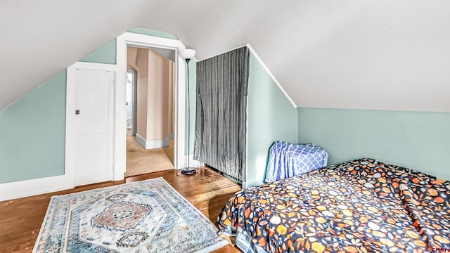 bedroom with lofted ceiling and wood-type flooring