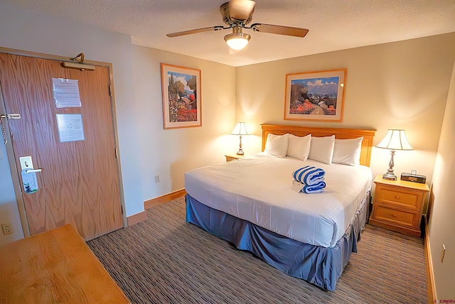 bedroom featuring a textured ceiling, ceiling fan, and dark carpet