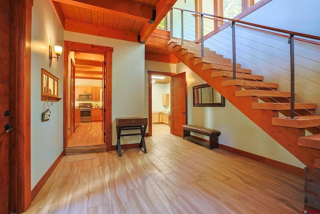 staircase with hardwood / wood-style floors, beamed ceiling, and wooden ceiling