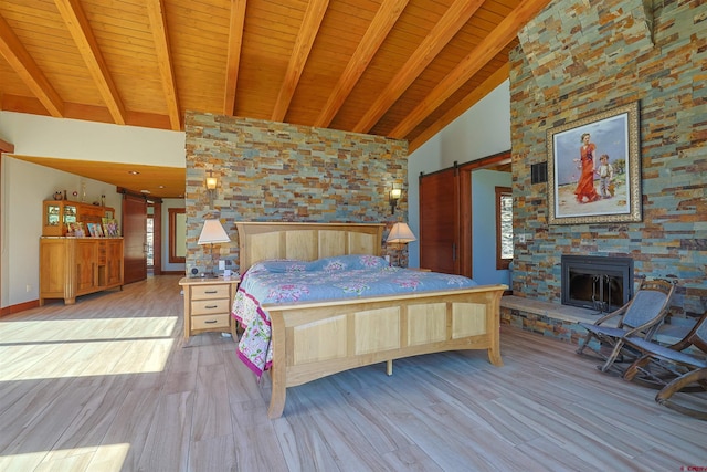 bedroom featuring beam ceiling, wood ceiling, a barn door, and high vaulted ceiling