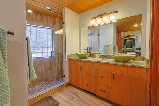 bathroom featuring vanity, a shower with door, and wooden ceiling