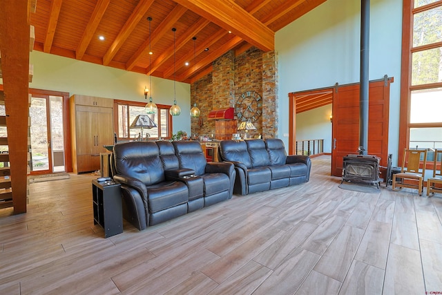 living room with high vaulted ceiling, beamed ceiling, a wood stove, and wooden ceiling