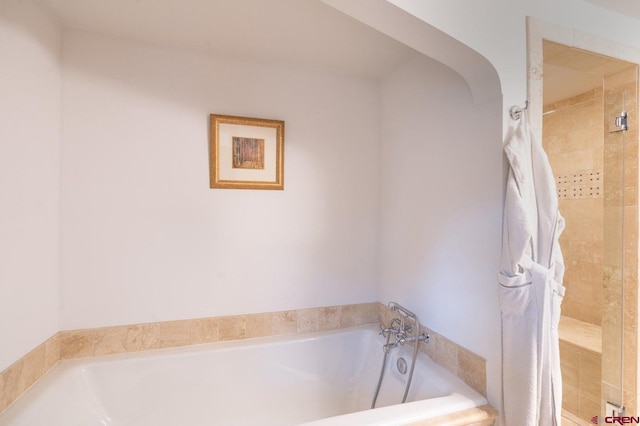 bathroom featuring a relaxing tiled tub