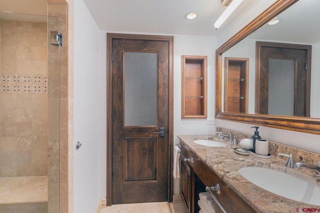 bathroom featuring tile patterned floors, tiled shower, and vanity