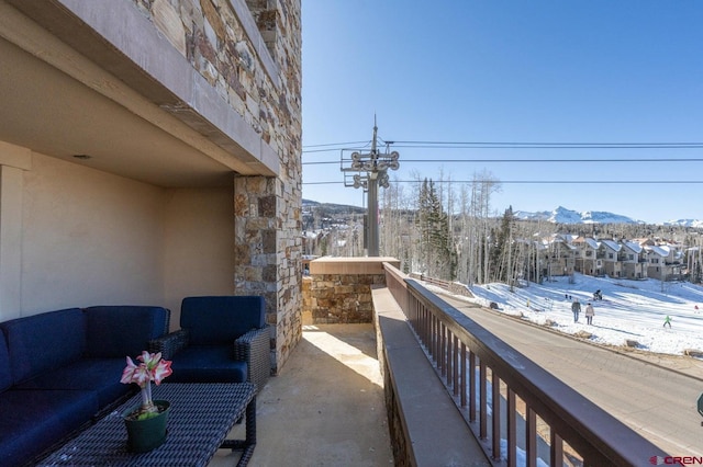 snow covered back of property featuring a mountain view