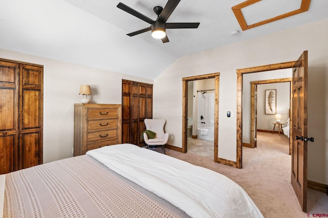 carpeted bedroom with ceiling fan, ensuite bathroom, and lofted ceiling