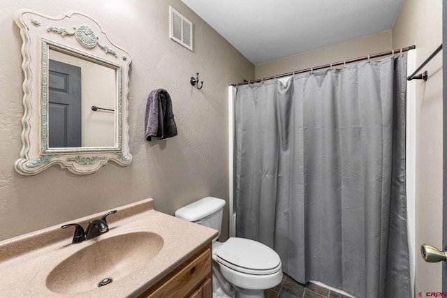 bathroom featuring vanity, toilet, and walk in shower