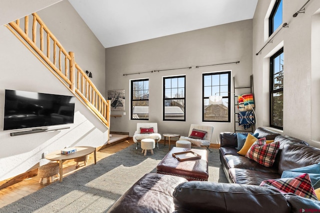 living room featuring wood-type flooring and high vaulted ceiling