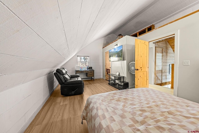 bedroom featuring light hardwood / wood-style floors and vaulted ceiling