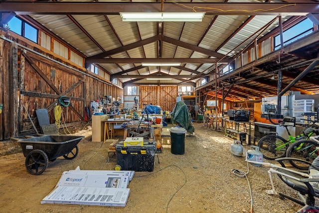 misc room with high vaulted ceiling and wood walls