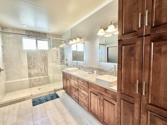 bathroom featuring vanity, a shower with door, and a textured ceiling