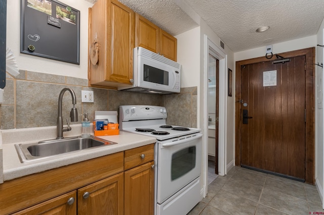 kitchen featuring decorative backsplash, sink, white appliances, and light tile patterned flooring