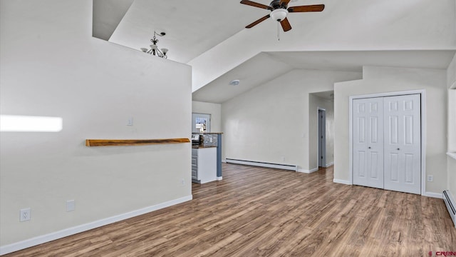 unfurnished living room featuring ceiling fan, baseboard heating, hardwood / wood-style floors, and lofted ceiling