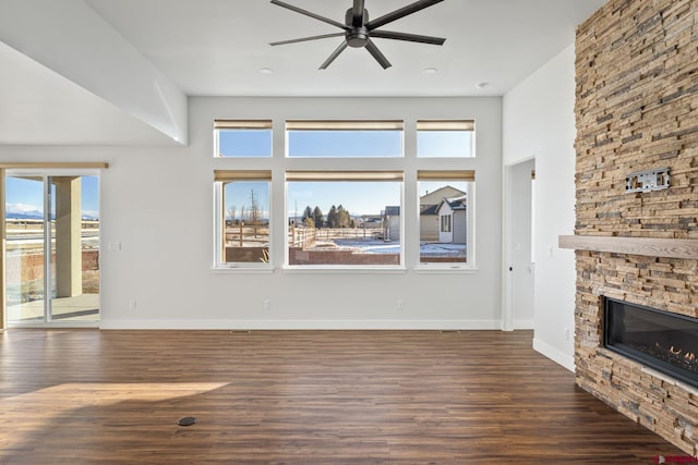 unfurnished living room with a fireplace, ceiling fan, and dark hardwood / wood-style flooring