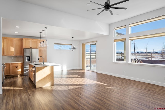 kitchen with tasteful backsplash, stainless steel fridge with ice dispenser, pendant lighting, a center island with sink, and dark hardwood / wood-style floors