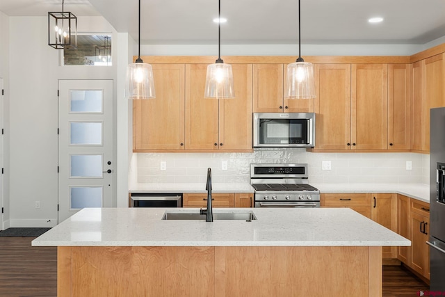 kitchen with sink, a center island with sink, light stone countertops, and appliances with stainless steel finishes