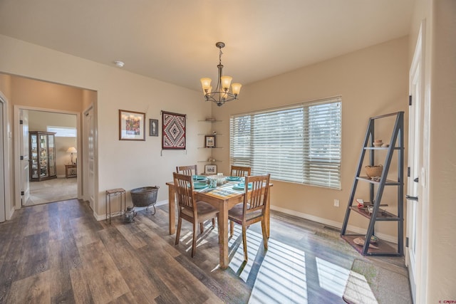 dining area with a notable chandelier and dark hardwood / wood-style floors