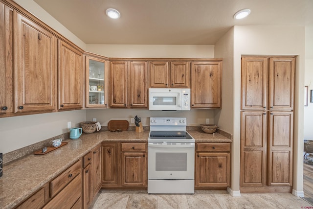 kitchen with light stone counters and white appliances