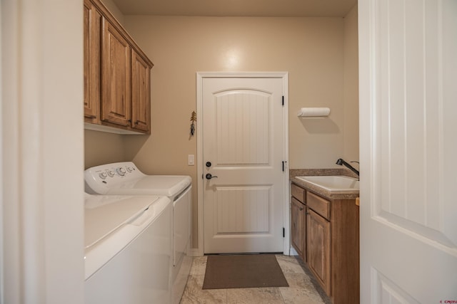 laundry room with cabinets, washer and dryer, and sink