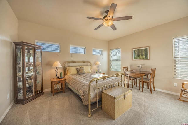 bedroom featuring multiple windows, light colored carpet, and ceiling fan