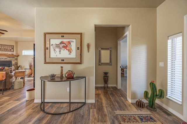 corridor with dark wood-type flooring and a wealth of natural light