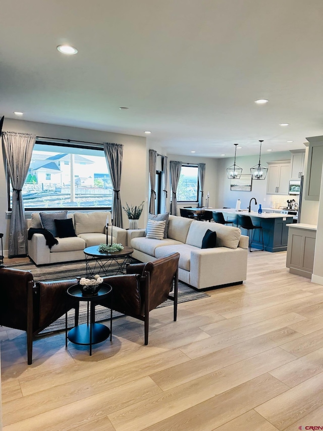 living room featuring sink and light hardwood / wood-style flooring