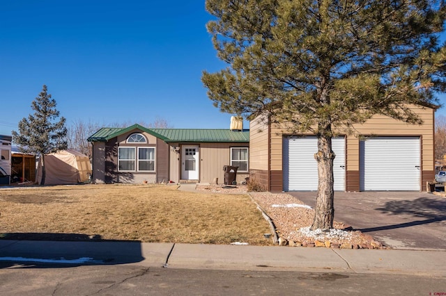 ranch-style home with a garage and a front lawn