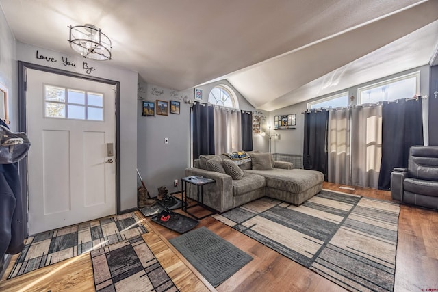 entryway with hardwood / wood-style floors and vaulted ceiling