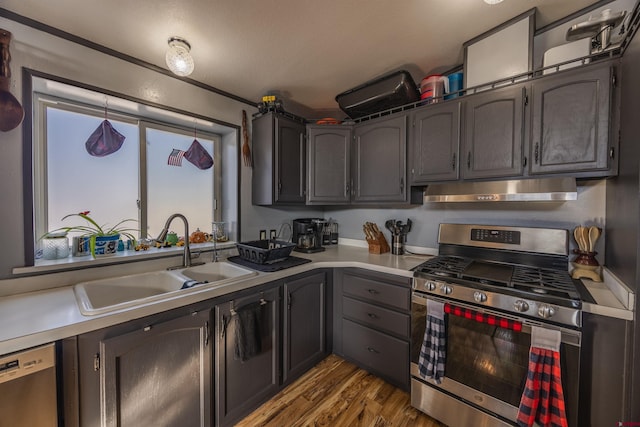 kitchen with stainless steel appliances, sink, and light hardwood / wood-style flooring