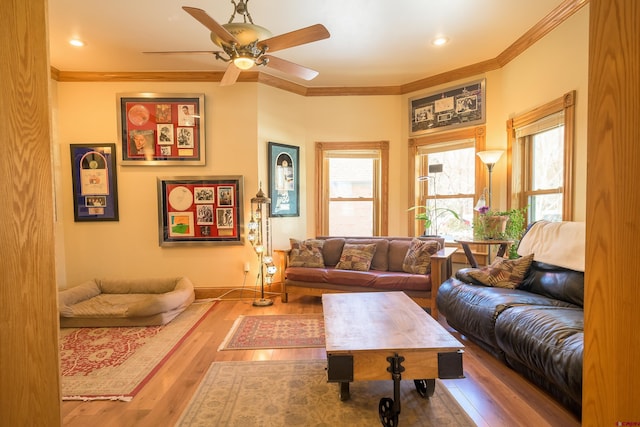 living room with wood-type flooring, ornamental molding, and ceiling fan